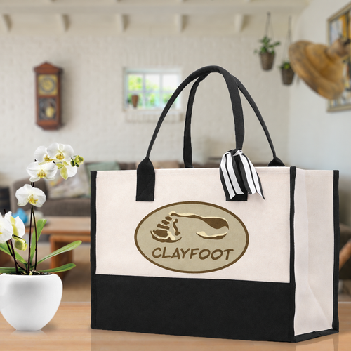 Digital artwork preview of the Clayfoot oval footprint logo on a natural canvas tote with black trim; supplier proof pending