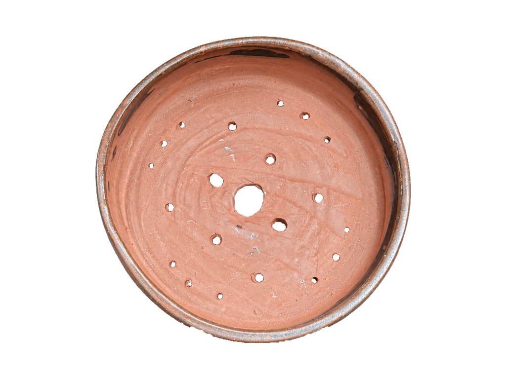 Interior of the bronze and copper pot showing its red clay, throwing marks and drainage and wiring holes