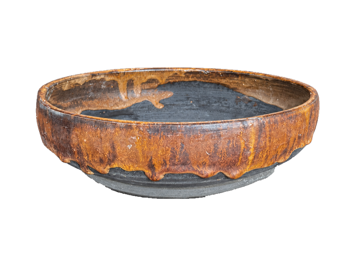 Alternate side of the amber and charcoal shallow pot showing flowing amber glaze over gray clay