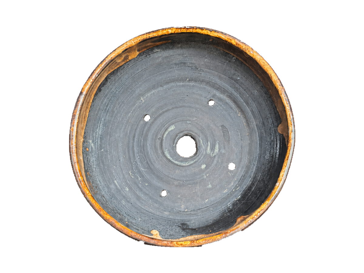Interior of the amber and charcoal pot showing its central drainage hole and four wiring holes