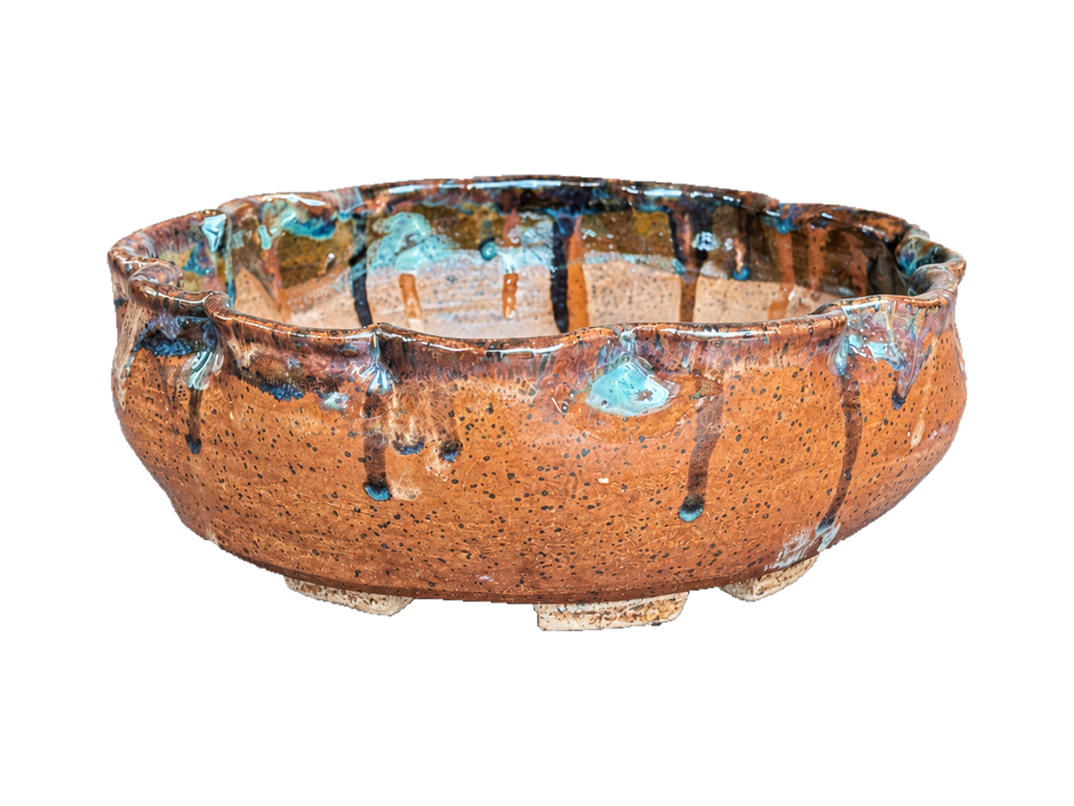 Alternate side of the terracotta scalloped pot showing blue glaze accents and speckled clay