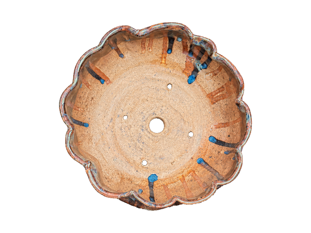 Interior of the terracotta scalloped pot showing its lobed rim and drainage and wiring holes