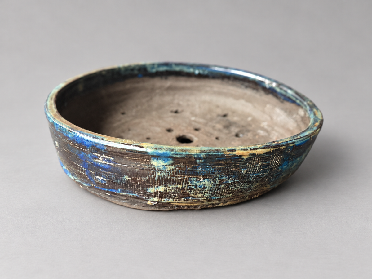 Alternate side view of the same blue and charcoal textured round ceramic pot