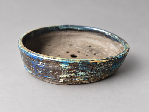 Alternate side view of the same blue and charcoal textured round ceramic pot
