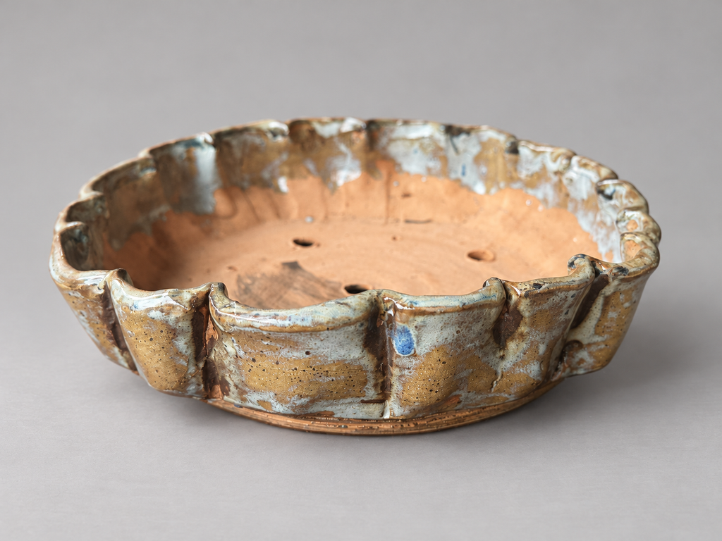 Alternate side view of the same ochre and cream scalloped ceramic pot