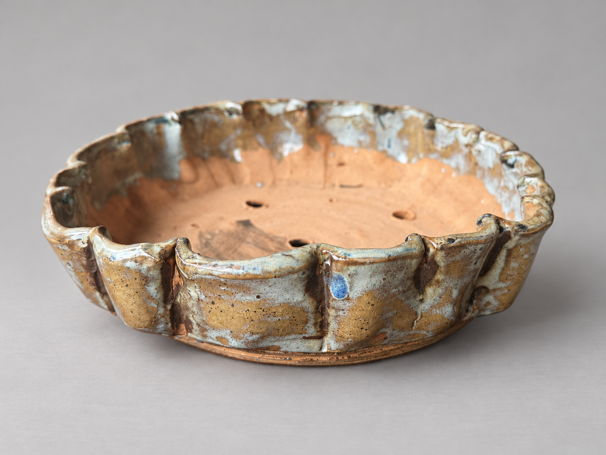 Alternate side view of the same ochre and cream scalloped ceramic pot